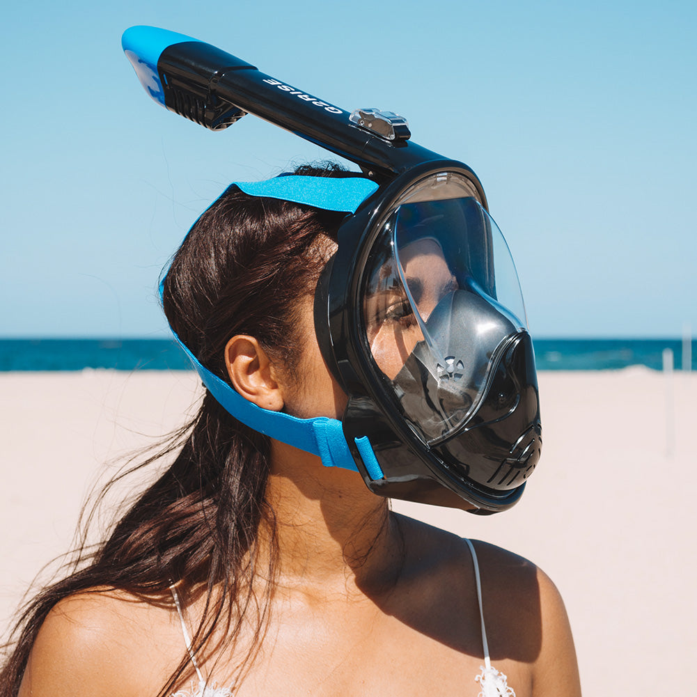 Woman with G2RISE full face snorkel mask on beach for underwater exploration