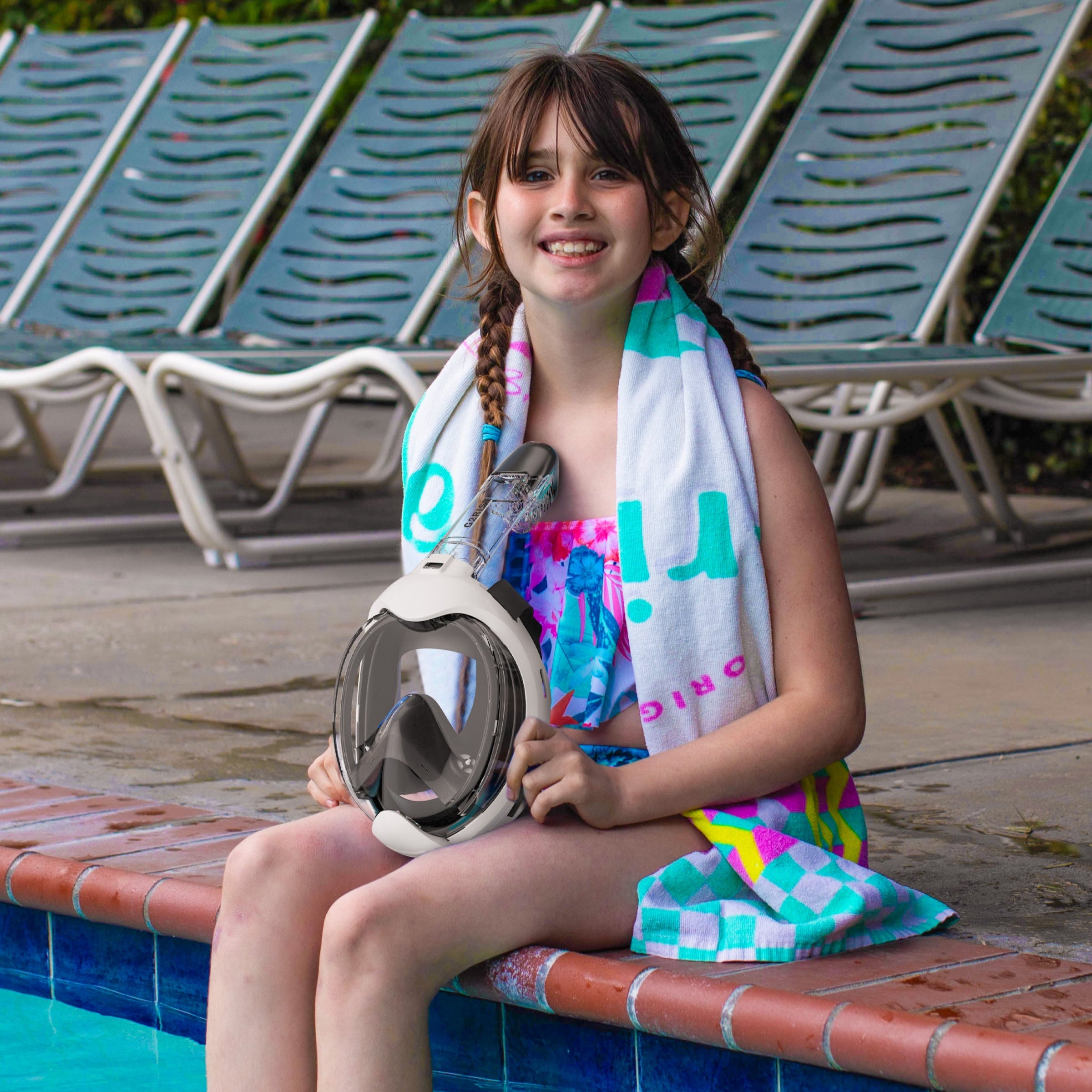 Girl sitting by pool holding G2RISE SN03 kids snorkel mask