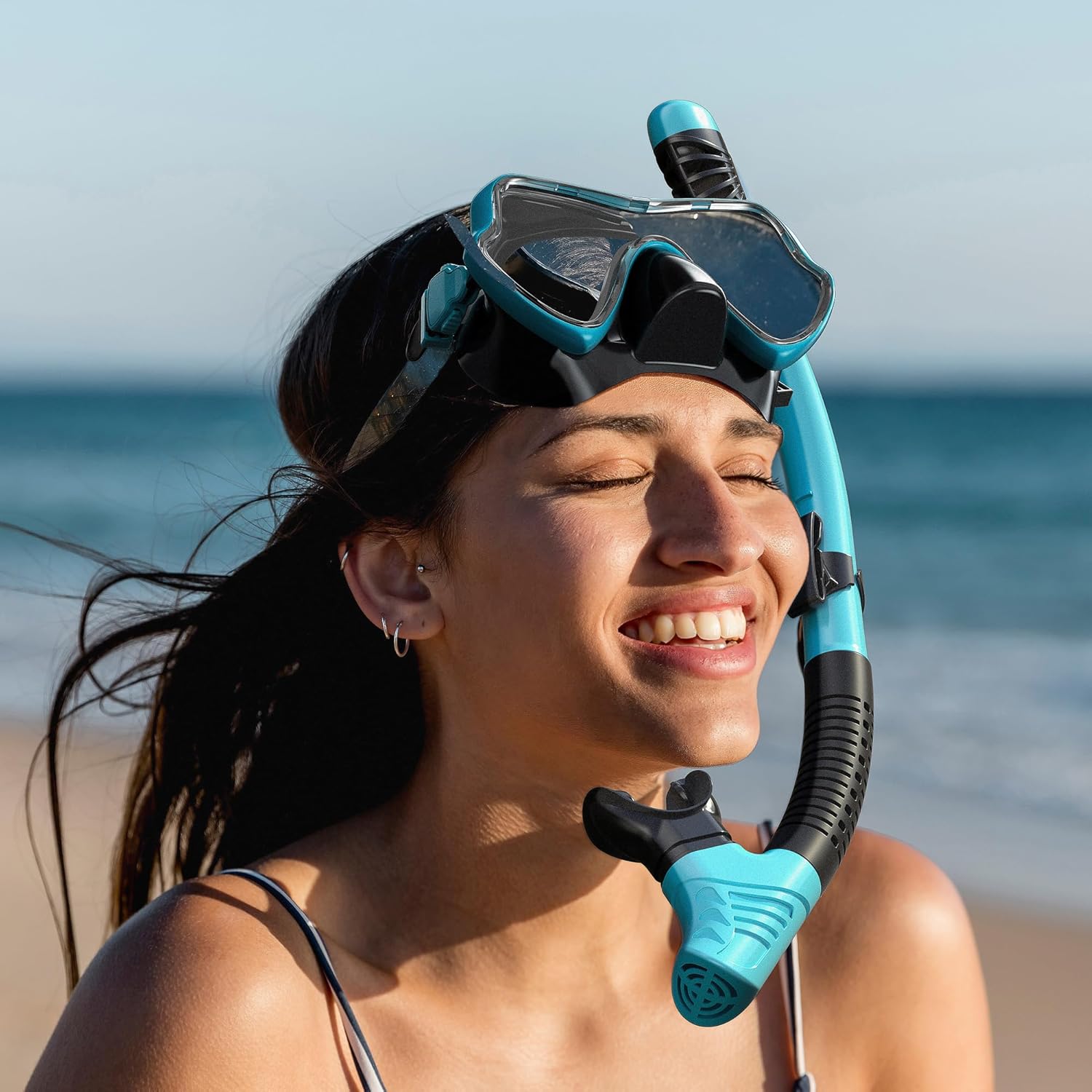 Smiling woman wearing blue snorkeling mask on beach